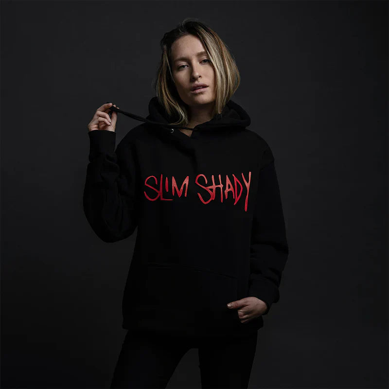 Person wearing a black hoodie with 'Slim Shady' text in red on a dark background